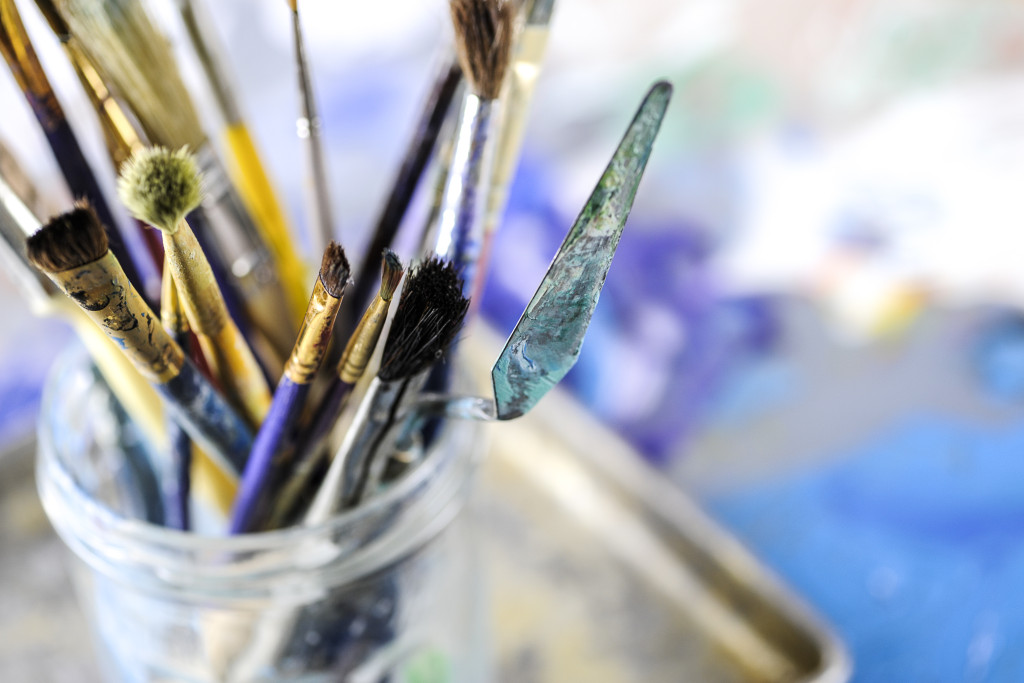 Macro view of dirty paint brushes in glass jar, shallow DOF