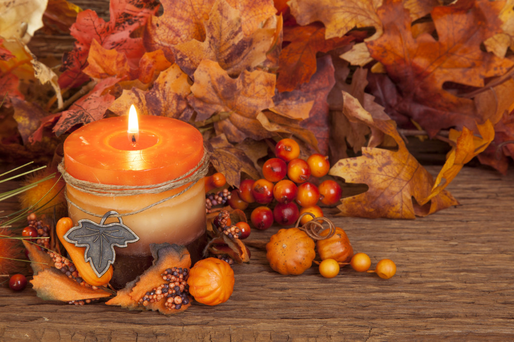 Autumn candle over wooden background