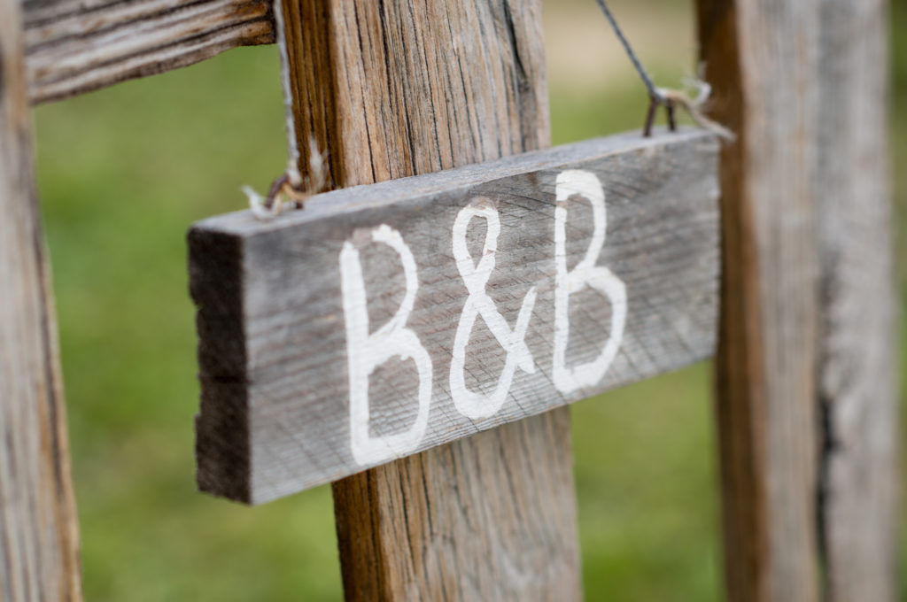 Closeup Of Old Signboard Bed & Breakfast Hanging On Fence