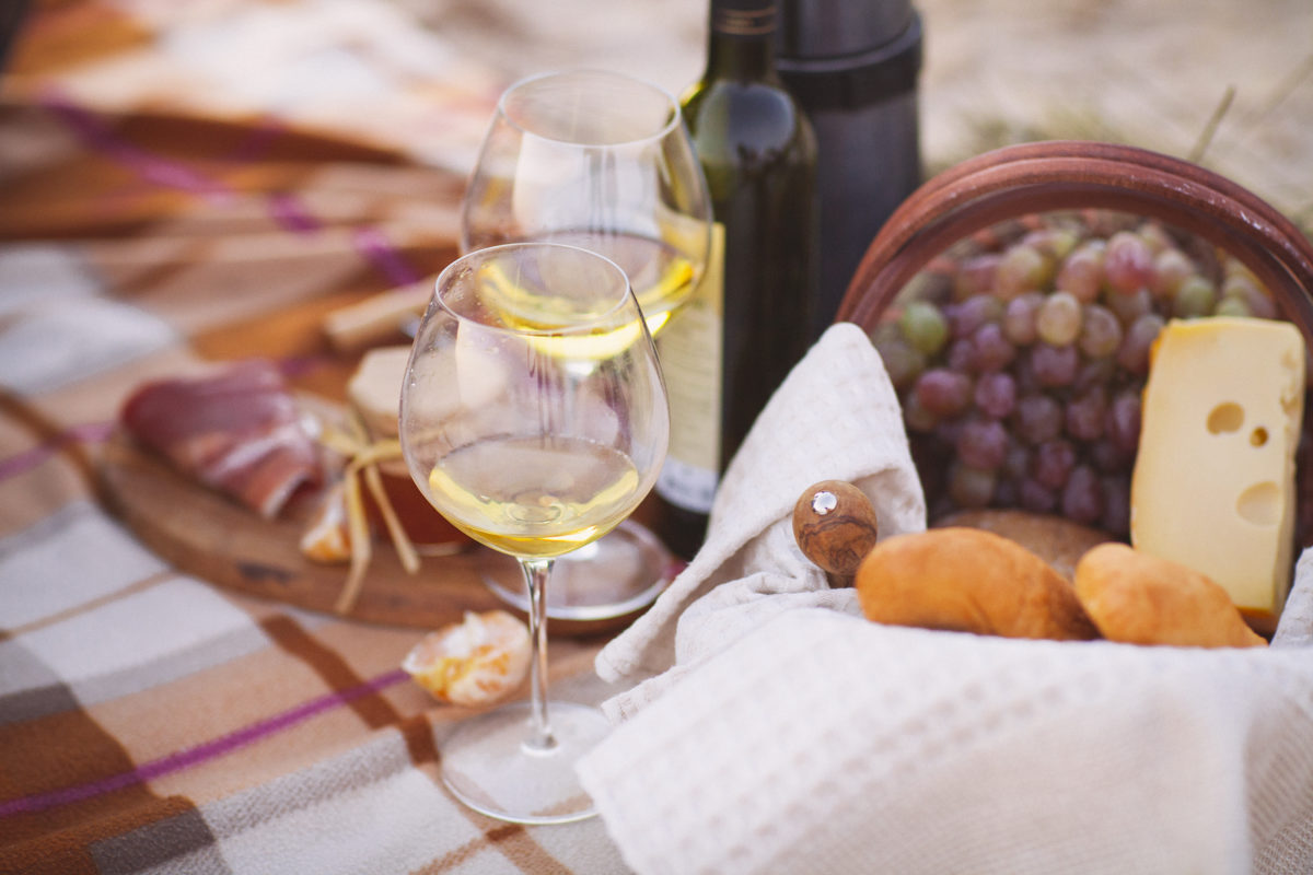 Autumn picnic by the sea with wine, grapes, bread, jam and cheese