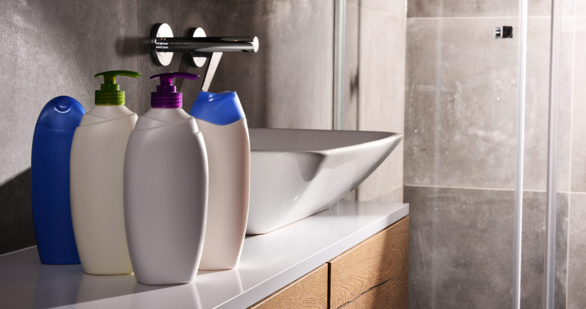 Plastic bottles of body care and beauty products in the bathroom.