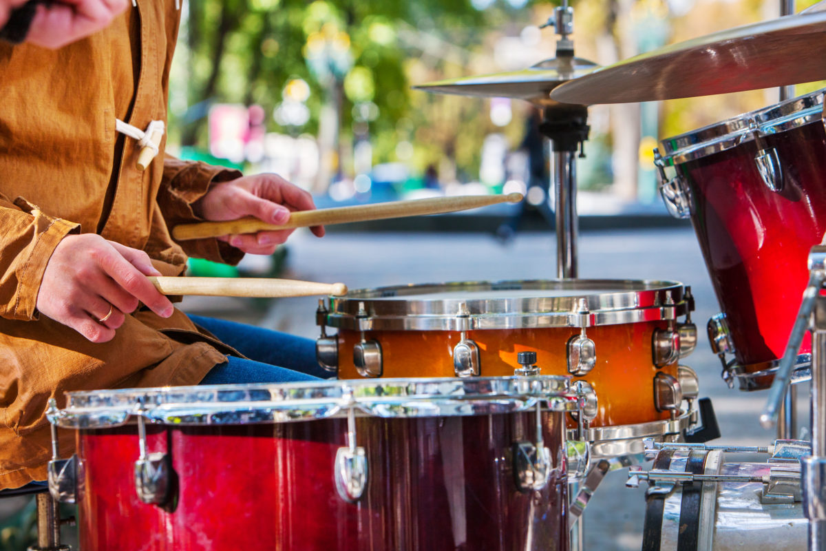 Music street performers on autumn park outdoor. Middle section of body part. Drums foreground in autumn park.