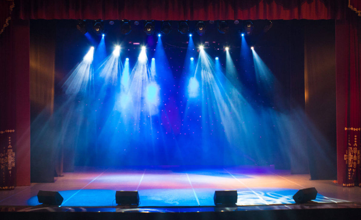 The stage of the theater illuminated by spotlights and smoke from the auditorium