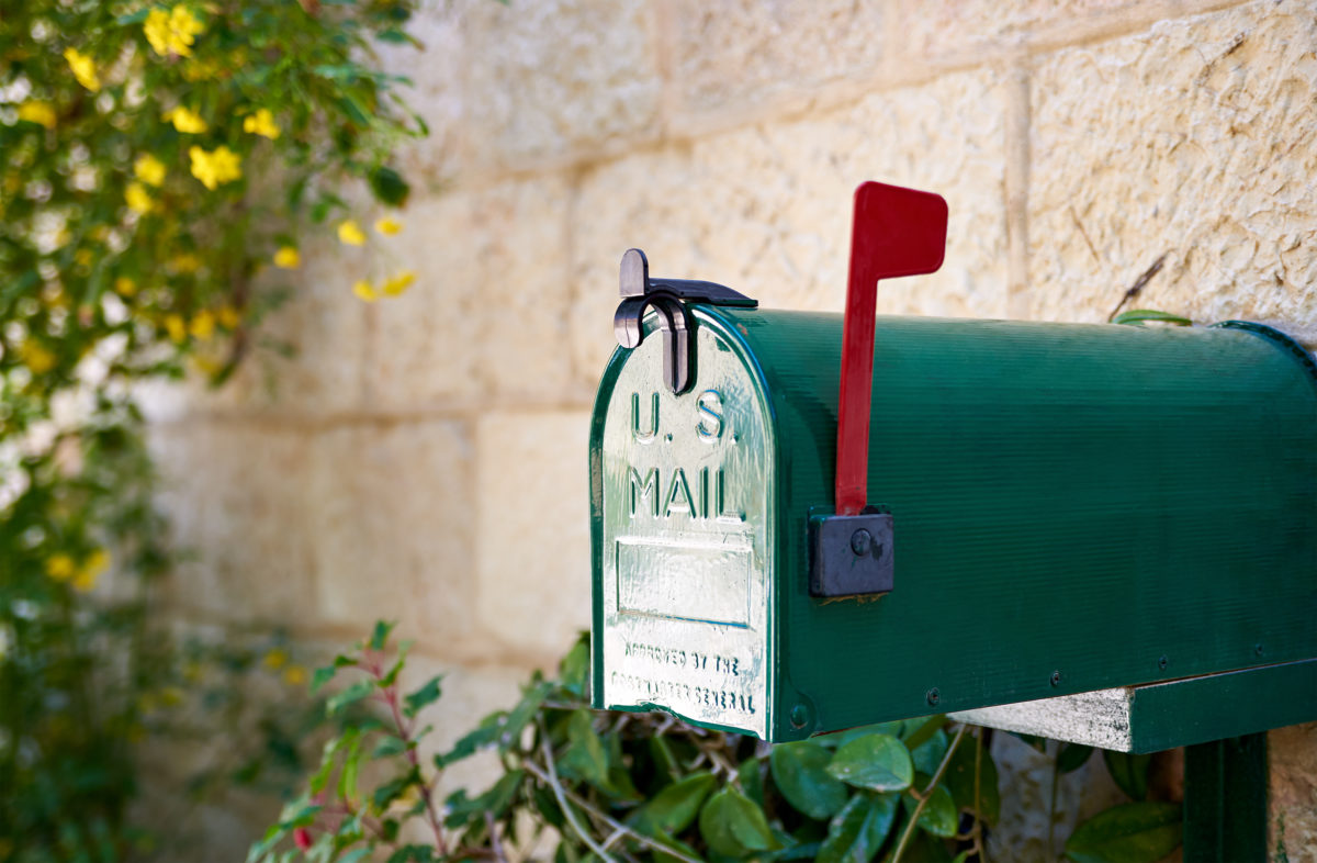 Green US post mail letter box with red flag raised up