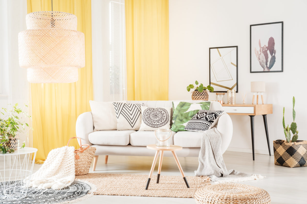 Patterned pillows lying on a cozy sofa in a bohemian living room interior