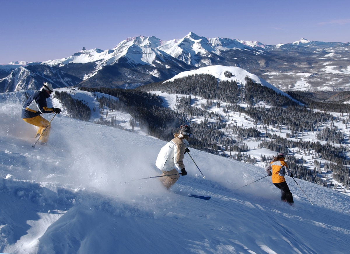 Skiers on Telluride's Gold Hill with the majestic Wilson Massif in the background