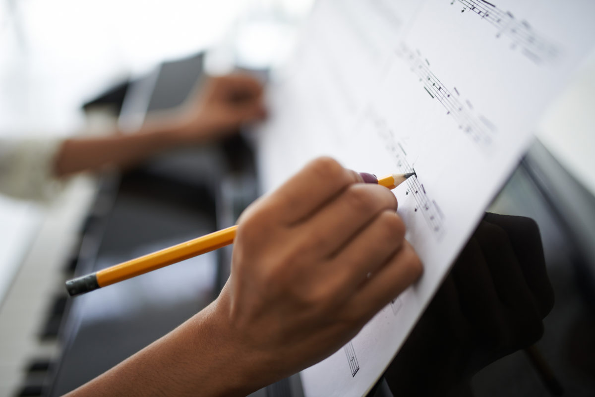 Close-up of female hands correcting music score