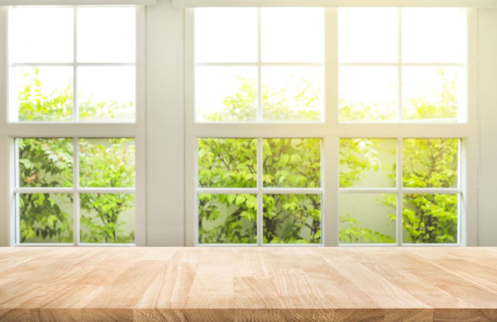 Top of wood table counter on blur window view garden background.For montage product display or design key visual layout