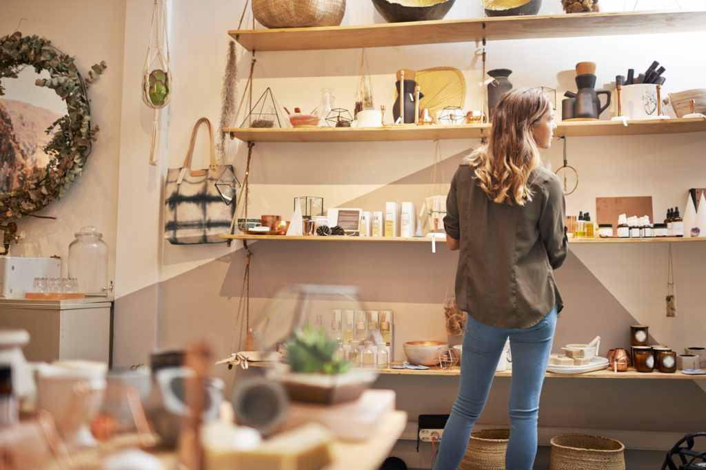 Rearview shot of a young woman looking at products on a shelf in a store